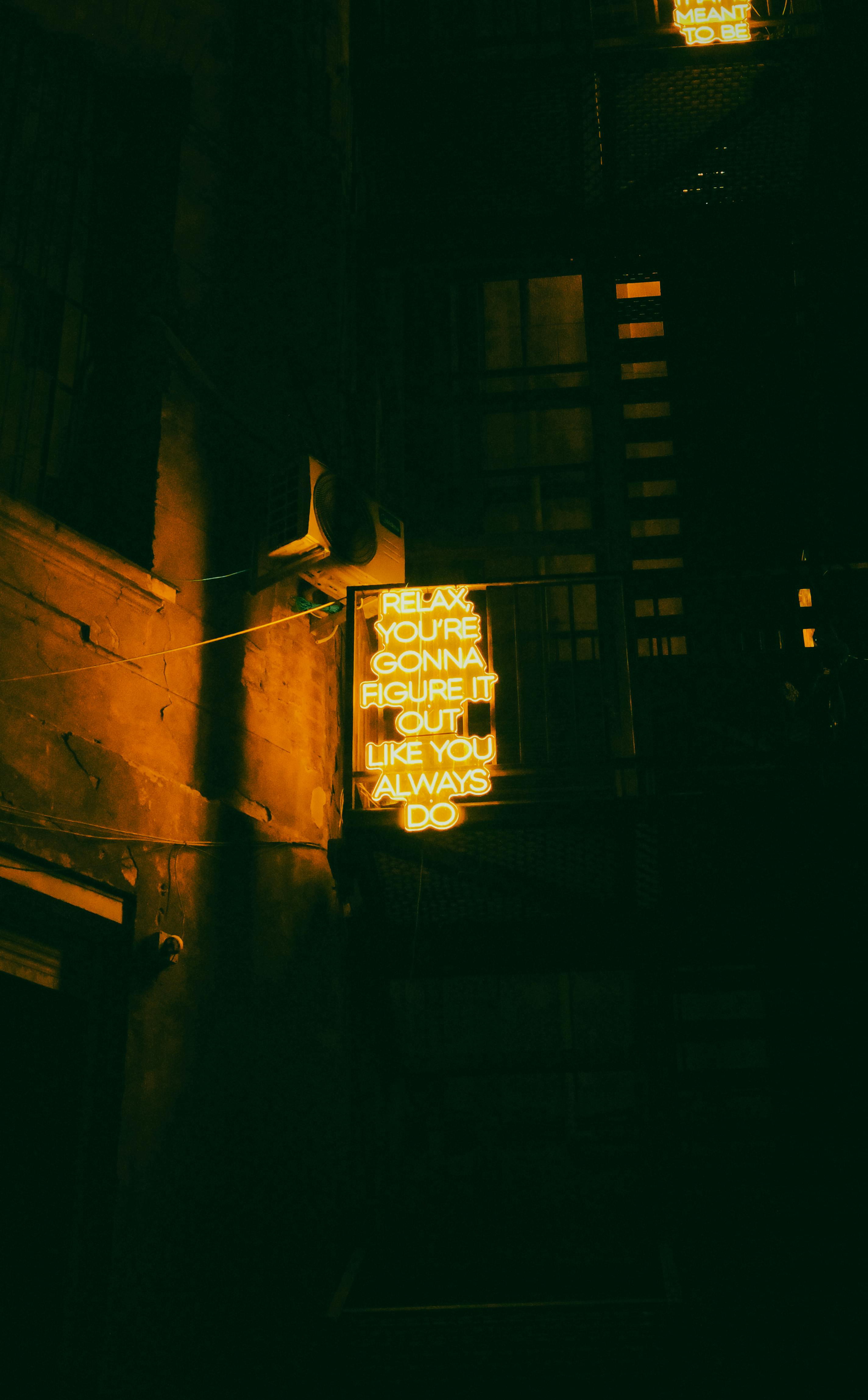 Ücretsiz Romanya'nın Bükreş kentinde loş bir sokakta ilham verici bir neon tabelanın yer aldığı kasvetli gece manzarası. Stok Fotoğraflar