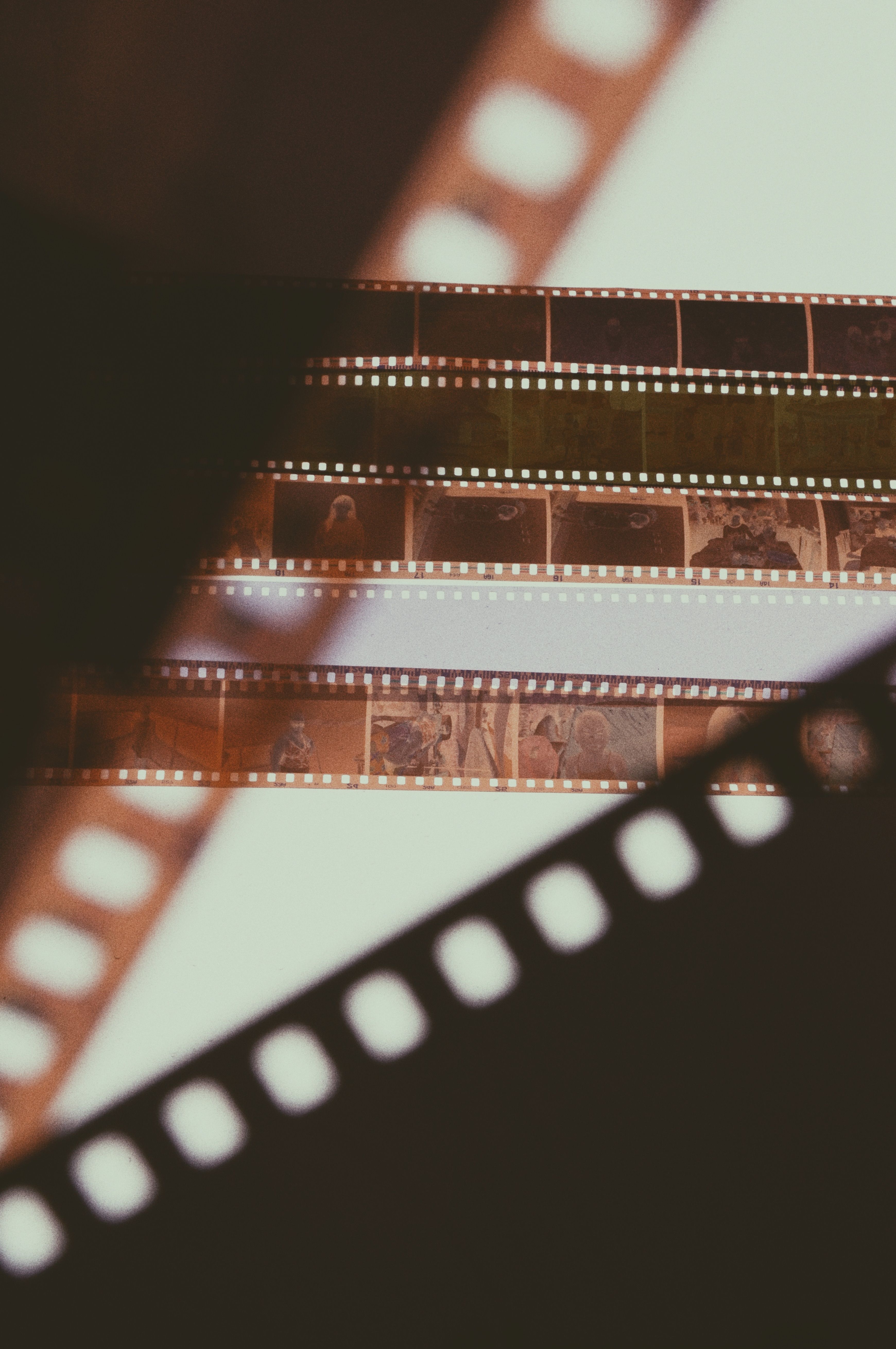 Free Close-up of overlapping vintage film strips with warm lighting and nostalgic feel. Stock Photo