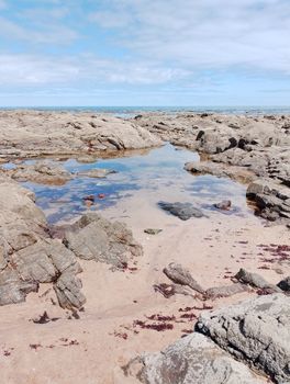 Scenic coastal landscape featuring rocky formations, a tidal pool, and the ocean under a bright sky.. pexels, scenic, coastal