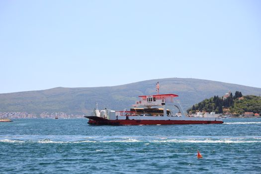 A ferry crossing scenic bay waters with mountainous background, perfect for travel exploration.