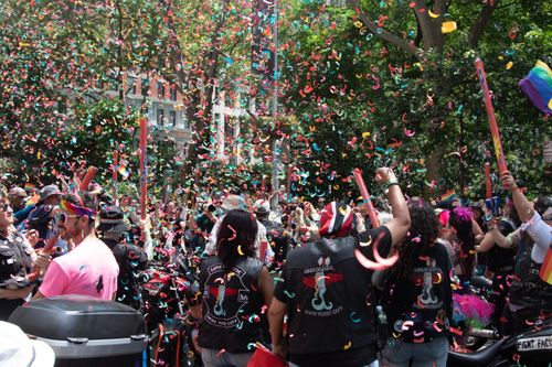 Free Exciting street parade in NYC with colorful confetti and diverse crowd celebrating pride. Stock Photo