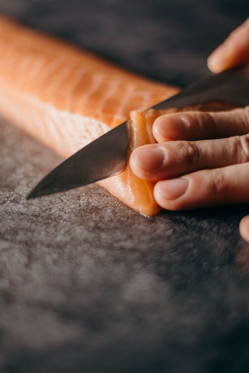 close up of someone cutting a salmon filet