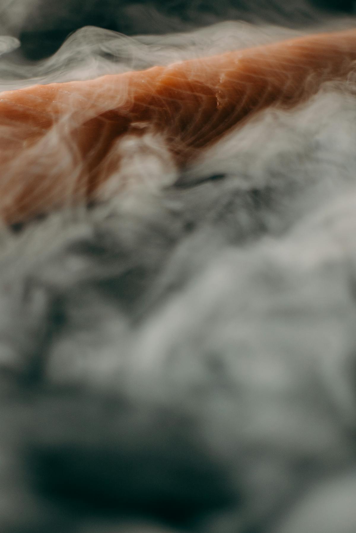 Finished salmon, quinoa, and vegetable bowl drizzled with creamy sauce.