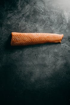 高品质的新鲜生鲑鱼片特写镜头，在纹理丰富的深色背景上，准备烹饪