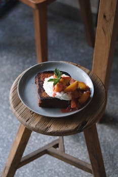 Delicious toast topped with cream and fresh fruit on a rustic wooden stool. Perfect for breakfast lovers.