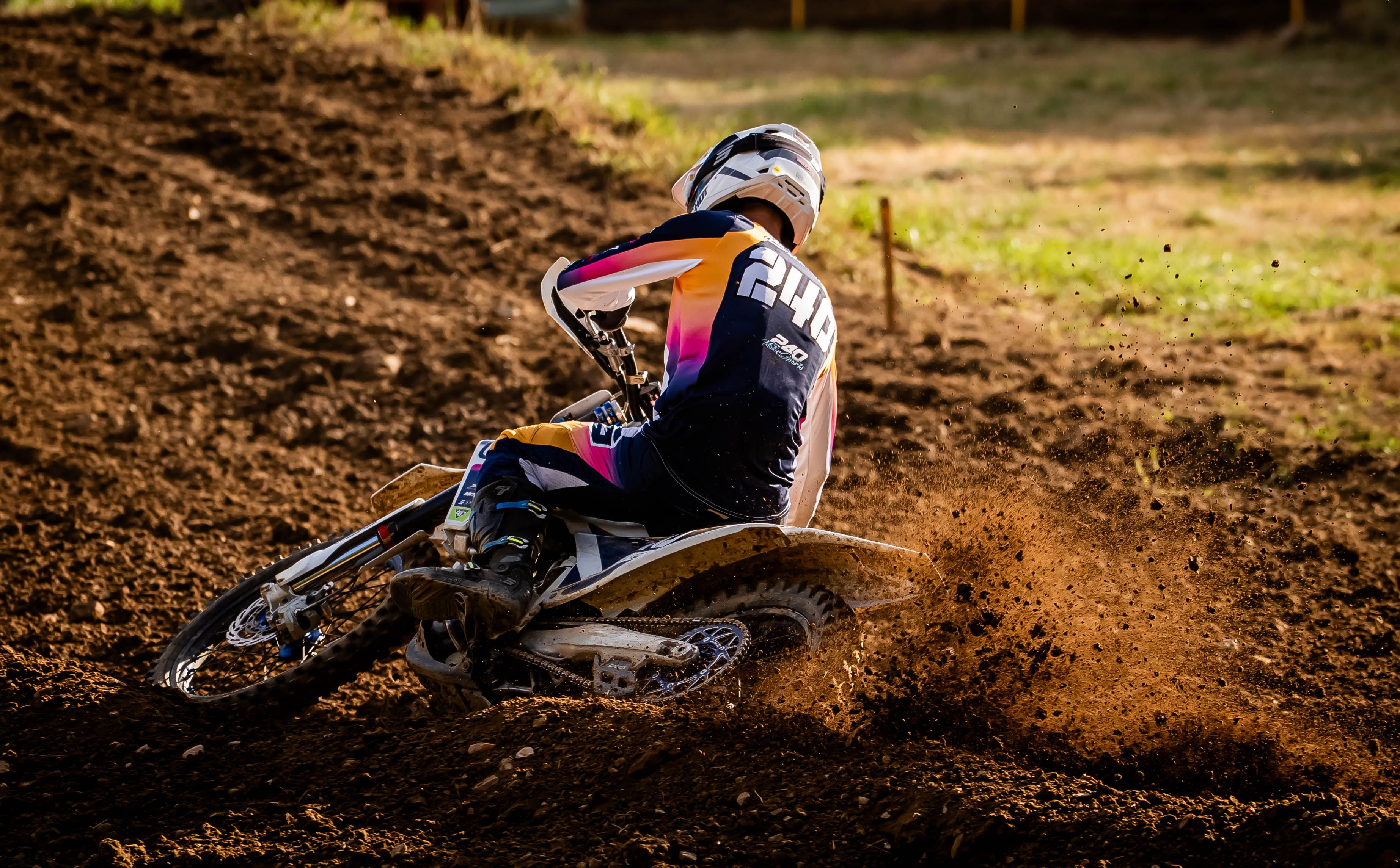 A thrilling action shot of a motocross rider making a sharp turn on a dirt track.