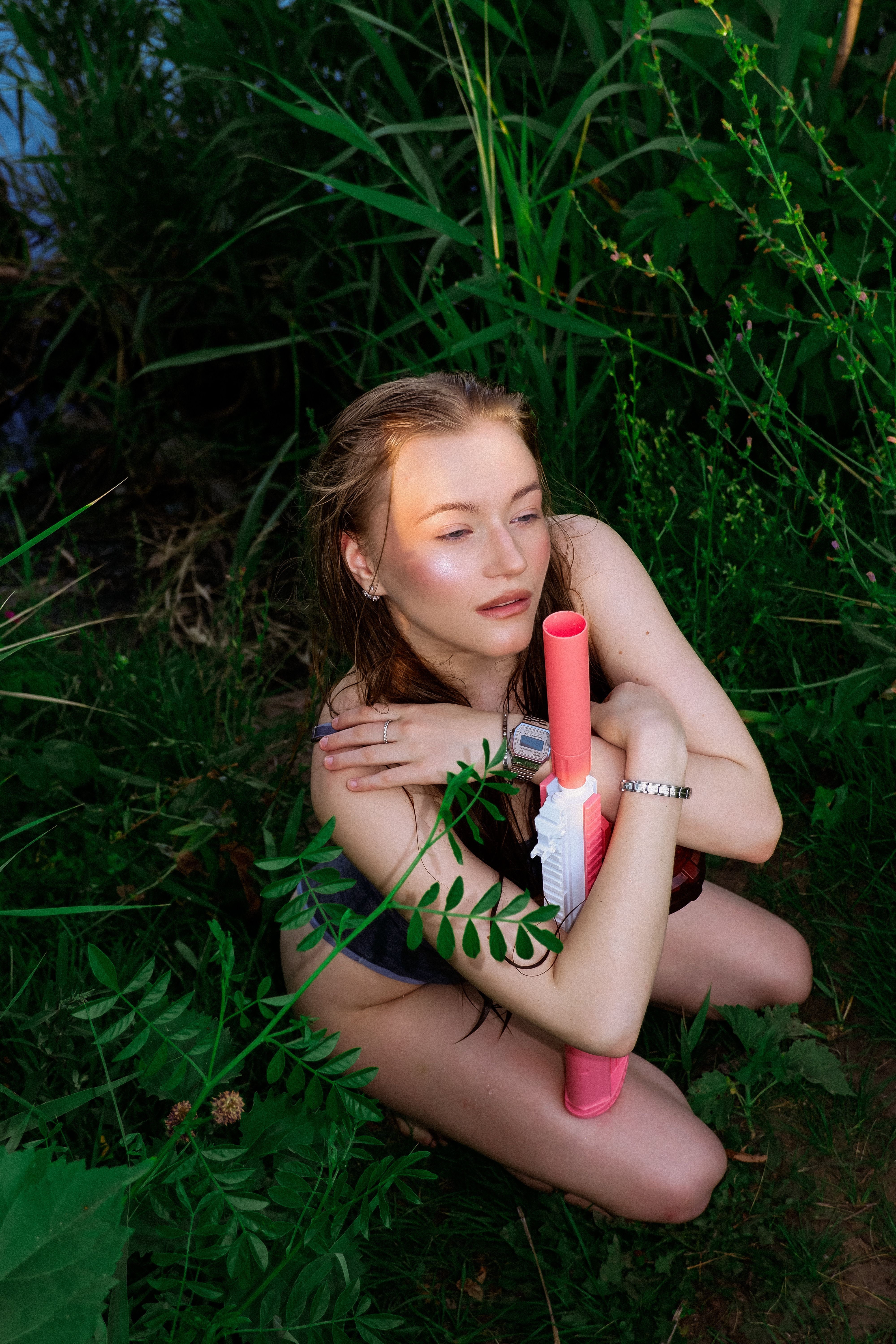 Young Woman Relaxing Outdoors with Toy Gun