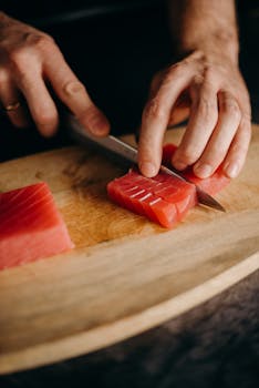 特写镜头：双手在木砧板上切新鲜金枪鱼，非常适合亚洲美食主题