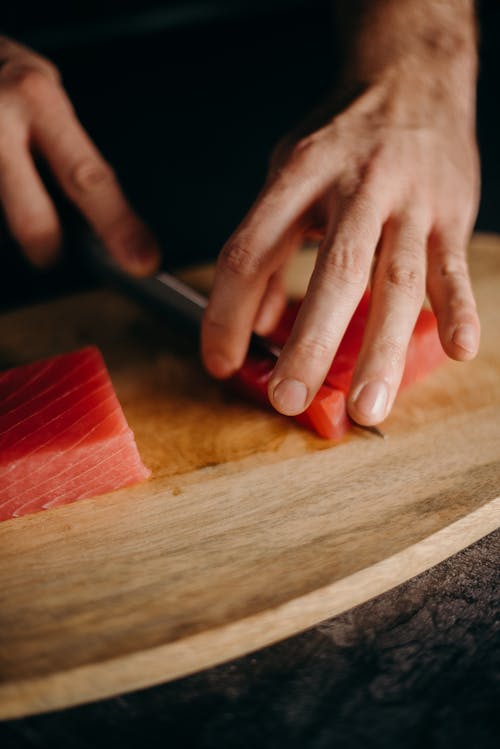 Person Holding Brown Wooden Chopping Board