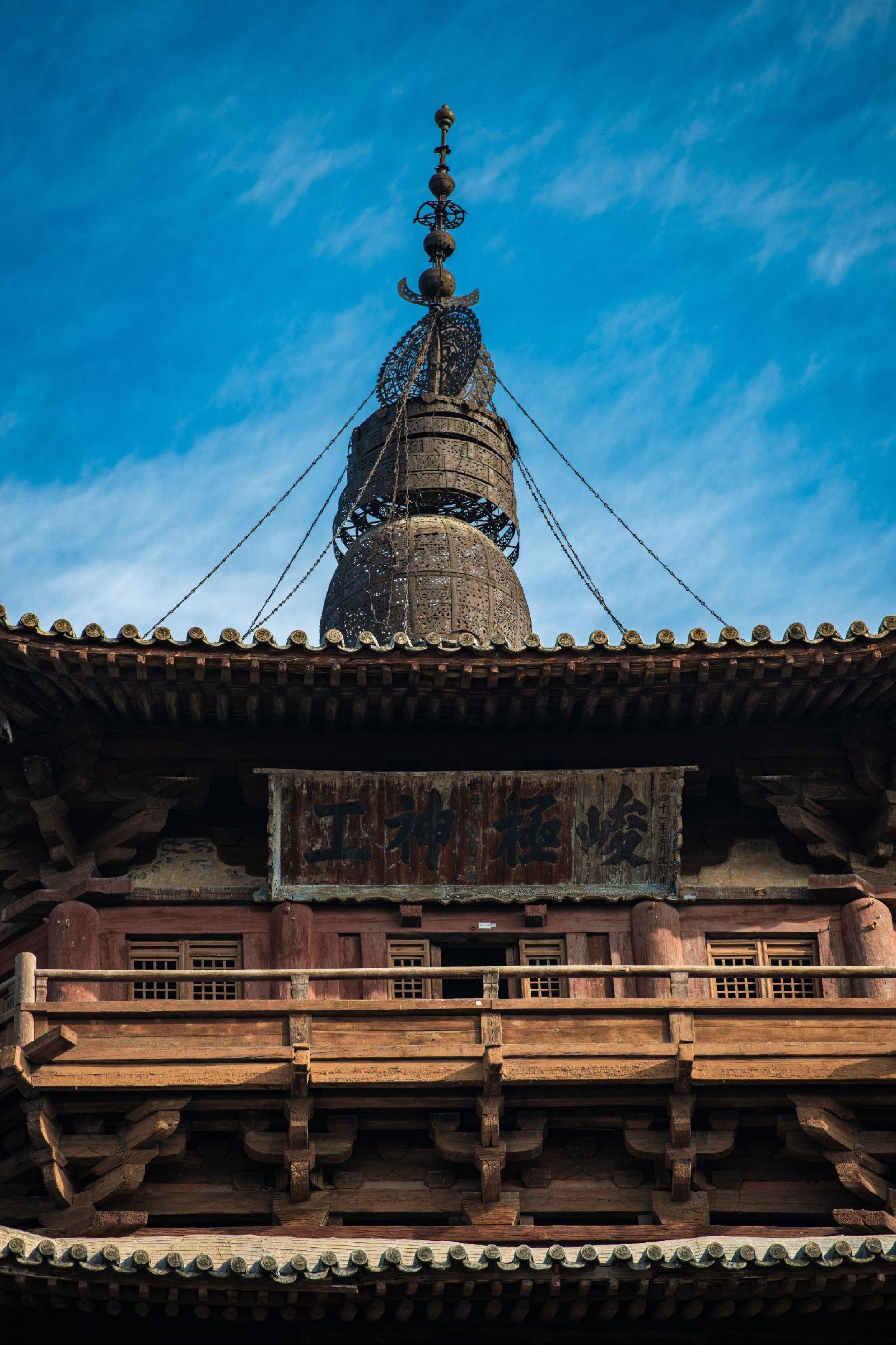 A detailed view of an ancient wooden pagoda in Shaanxi, showcasing exquisite traditional Chinese architecture.