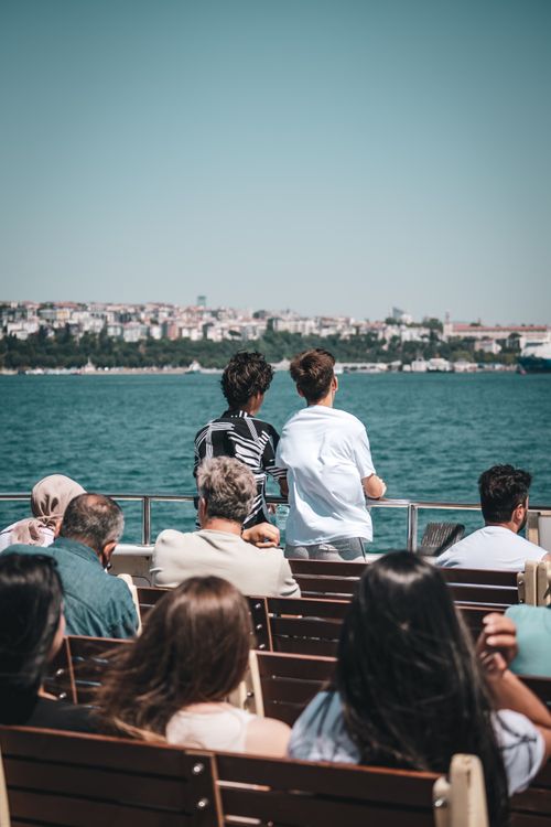 Free People enjoying a ferry ride on the Bosphorus with Istanbul skyline in the background. Stock Photo