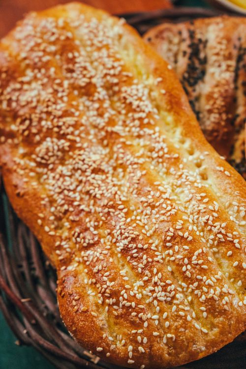 Free Close-up of a freshly baked sesame bread loaf on a wicker basket. Stock Photo