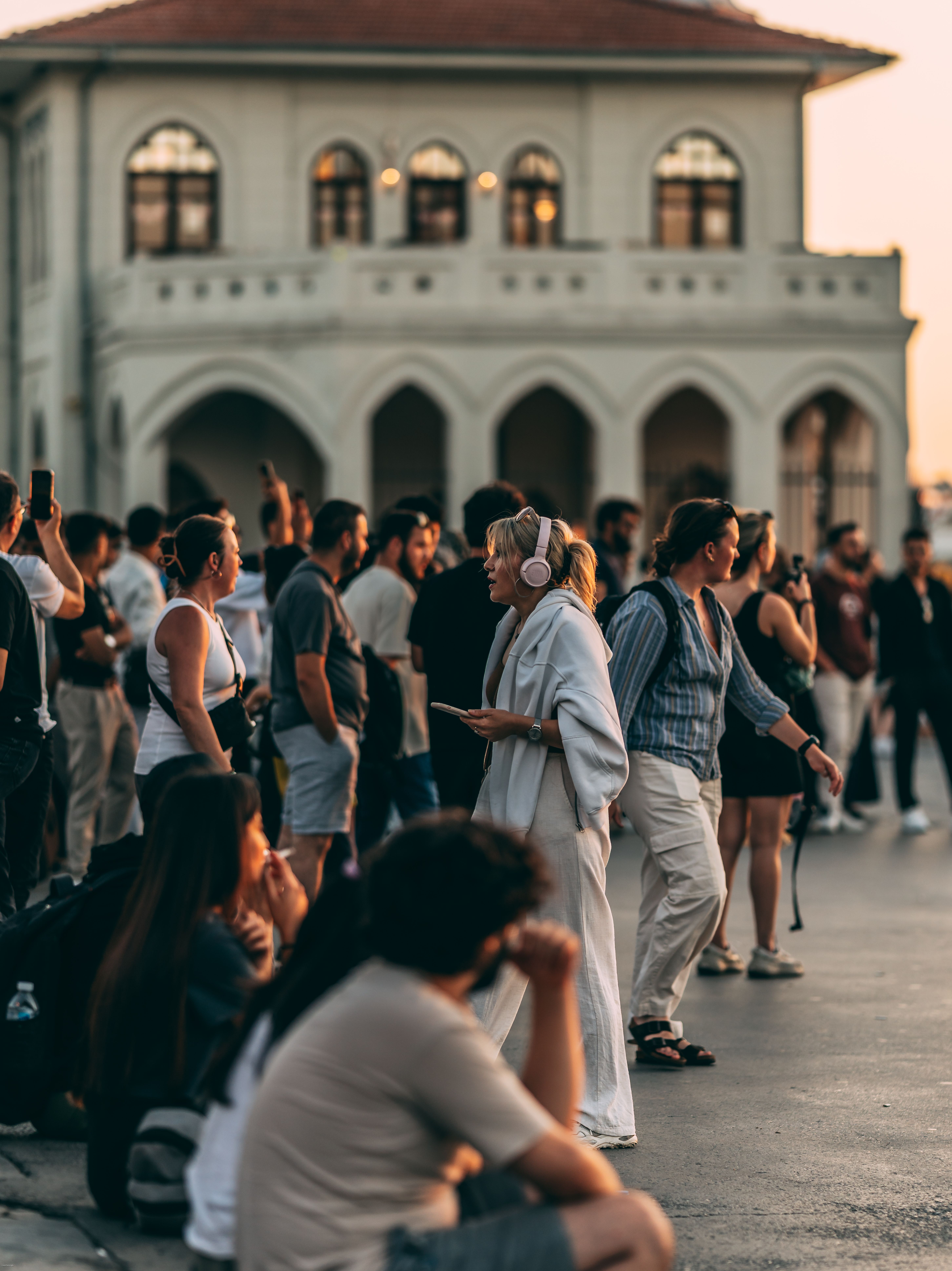 Fotomural Una multitud vibrante se reúne cerca de un hito arquitectónico en Estambul al atardecer.
