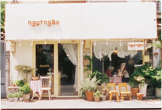 A cozy cafe with a vintage exterior, surrounded by lush plants, inviting customers in.