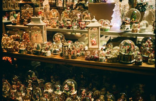 Charming collection of Christmas snow globes and festive decor with warm lighting creating a cozy holiday atmosphere.