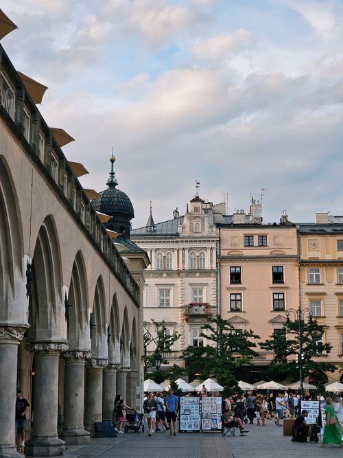 Free Elegant market square scene in Kraków, Poland featuring historic architecture and lively atmosphere. Stock Photo