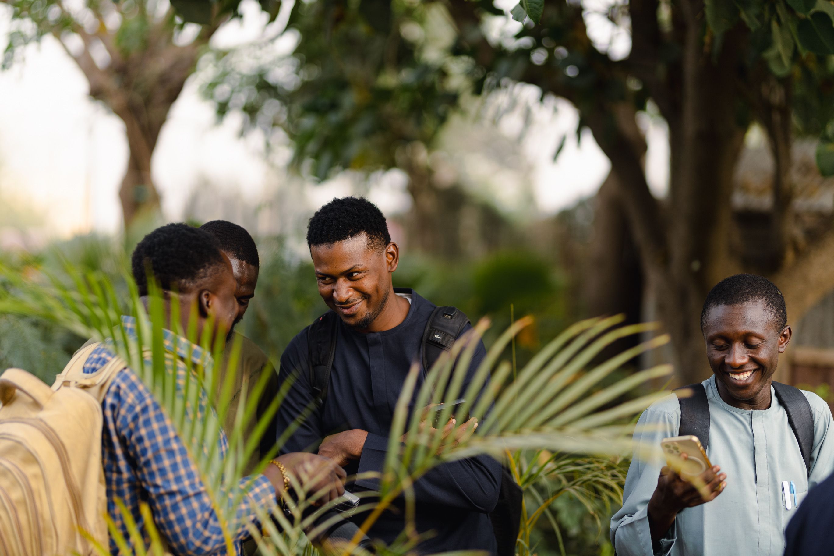 People networking and chatting warmly outside a modern church building in Ho, Ghana during golden hour
