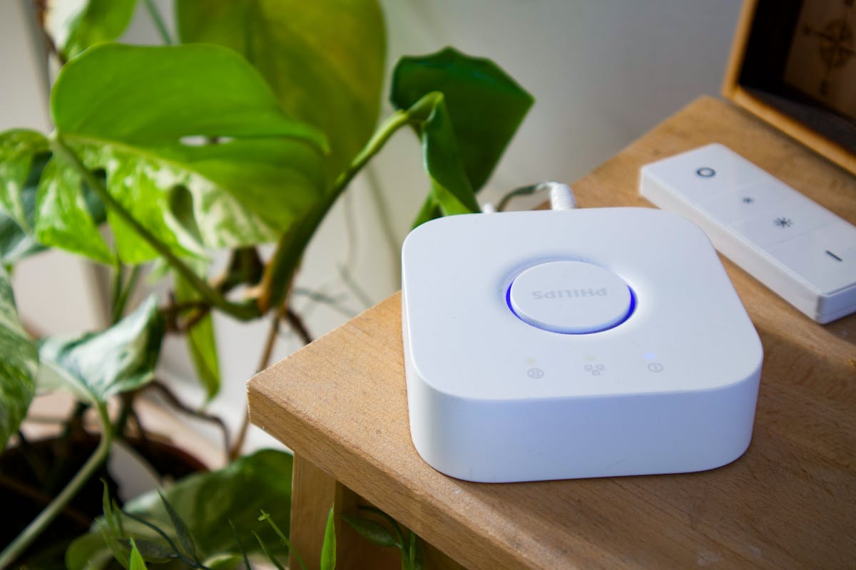 Hub smart Philips posizionato su una scrivania moderna accanto a una pianta