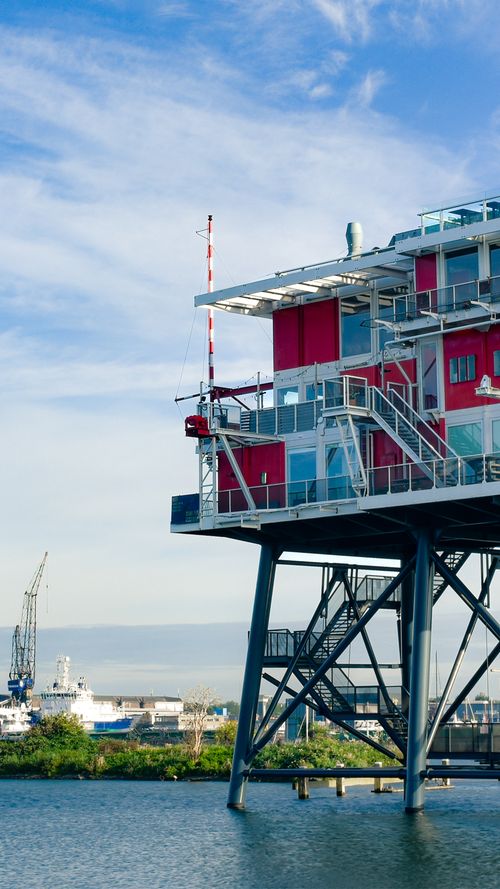 Free A striking modern architectural structure elevated on stilts over the water in Amsterdam, Netherlands. Stock Photo