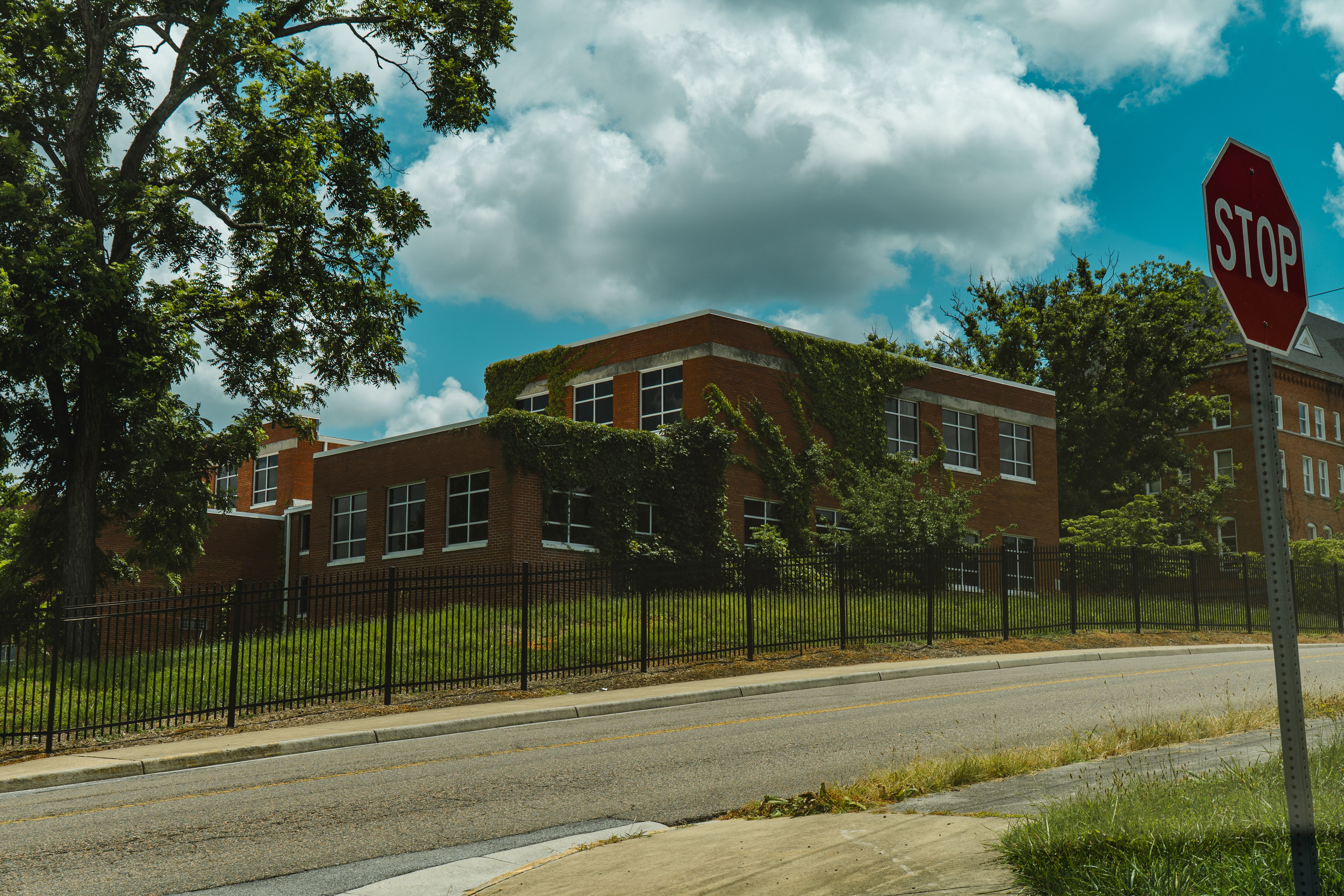 Abandoned brick building with overgrown ivy in Bristol, Virginia, under a clear sky.
