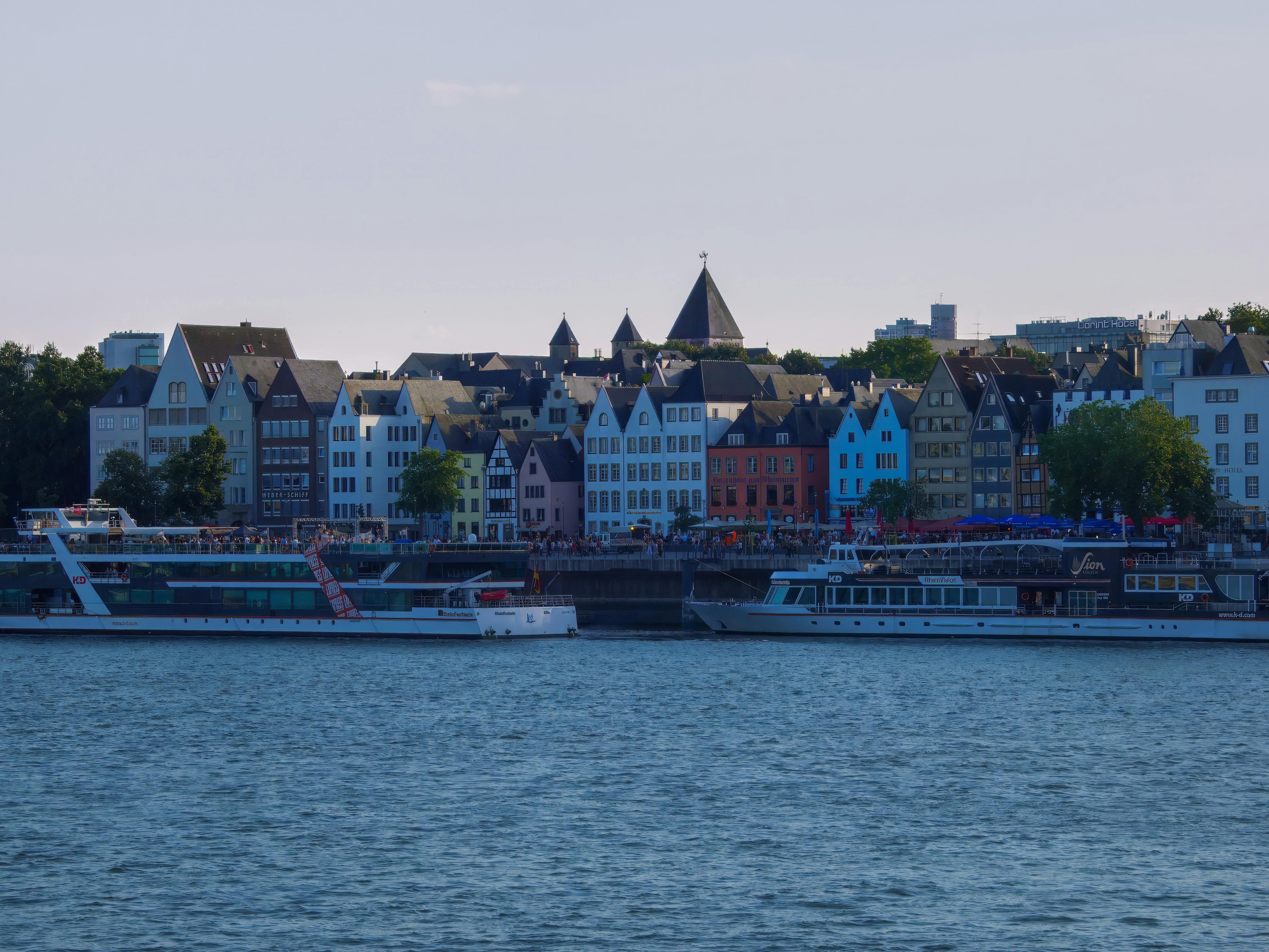 River cruise boats dock along a waterfront lined with colourful buildings and historic rooftops