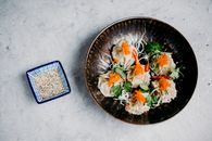 亚洲饺子的顶视图，上面装饰着鱼子和香菜，并配有芝麻