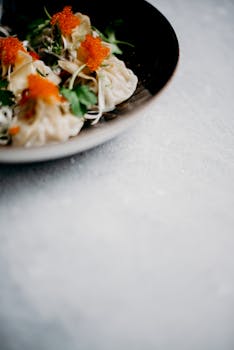 Elegant presentation of dumplings topped with vibrant roe and herbs, ideal for Asian cuisine enthusiasts.