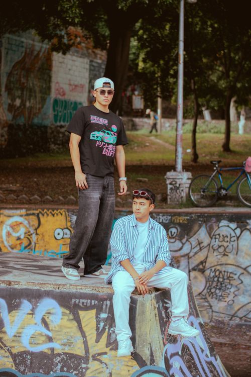 Free Two young adults showcase street fashion amidst vibrant graffiti in an urban skate park. Stock Photo
