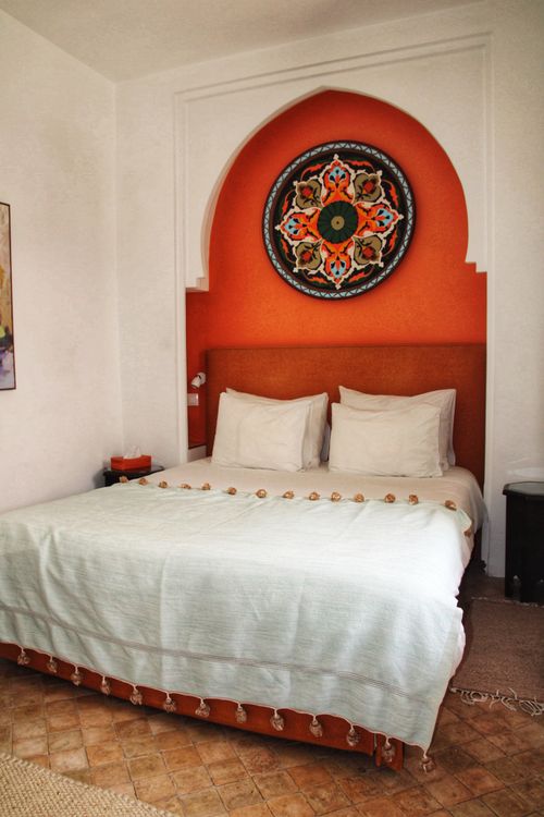 Free Cozy bedroom featuring Moroccan decor with arch design and vibrant wall art. Stock Photo