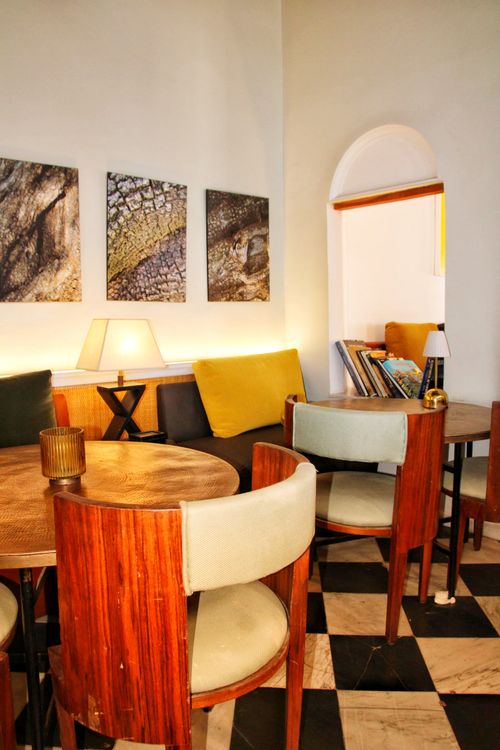 Free Warm, inviting cafe interior with wooden furniture, abstract art, and chessboard flooring. Stock Photo