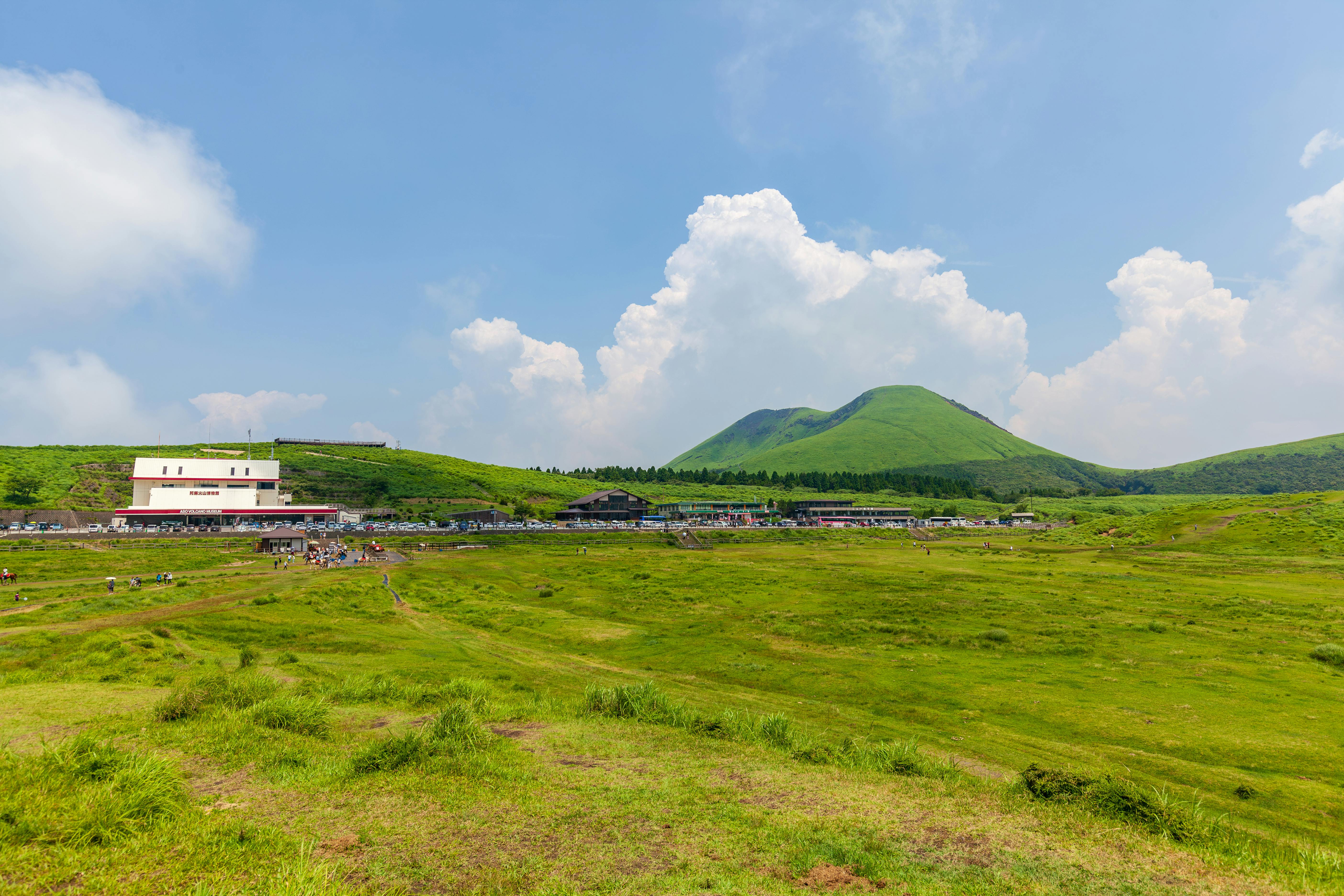 Vibrant green landscape with volcanic hills and blue skies at Aso, Kyushu, Japan.