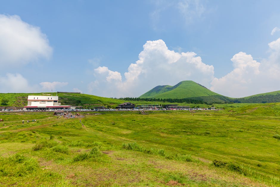 Vibrant green landscape with volcanic hills and blue skies at Aso, Kyushu, Japan.