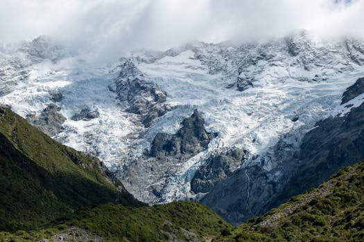 Breathtaking view of Aoraki Mount Cook with rugged glaciers and lush greenery in New Zealand.