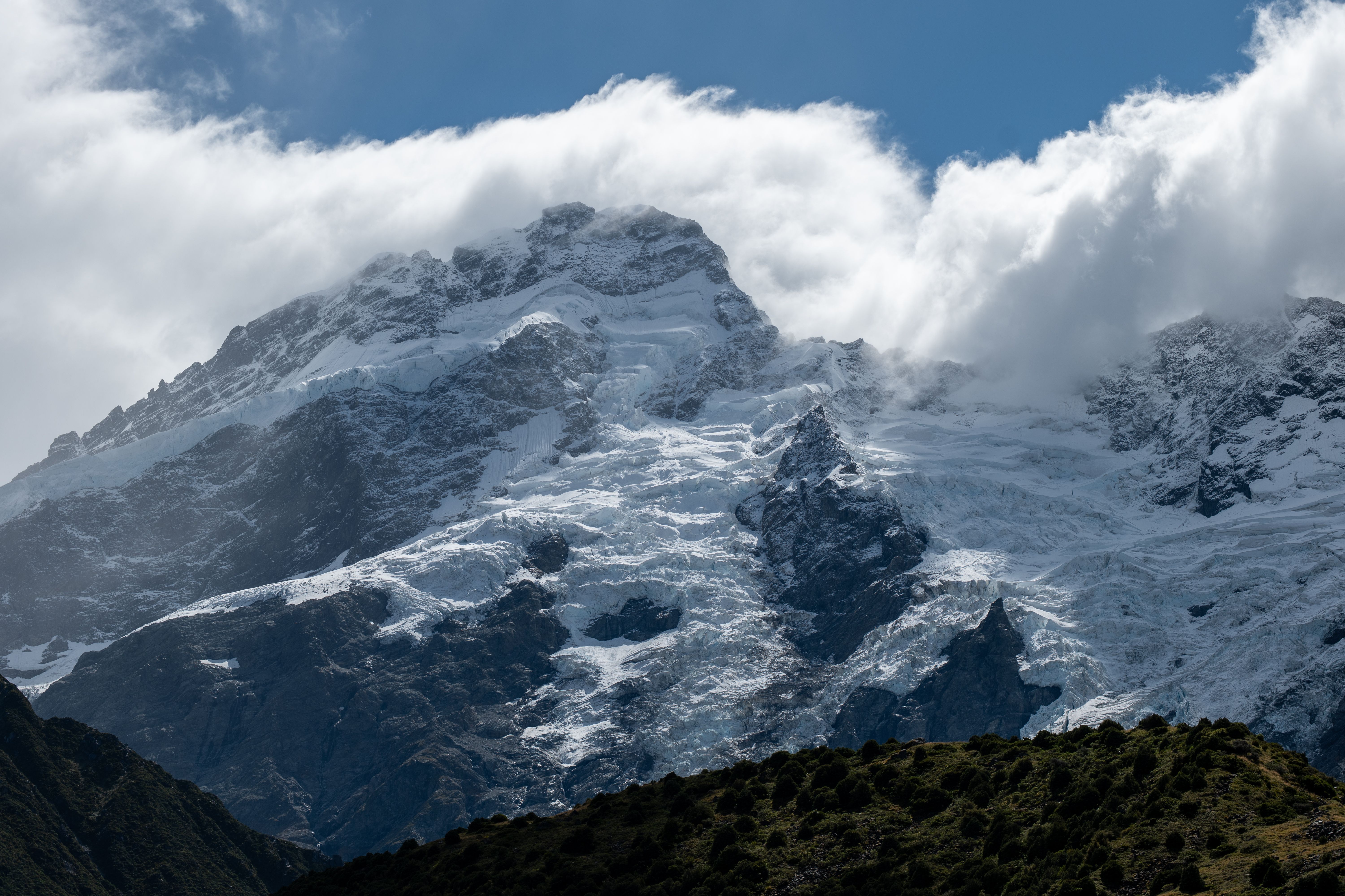 Makalu Expedition - Breathtaking view of Aoraki / Mount Cook with its snow-covered peaks surrounded by clouds in the Canterbury Region, New Zealand.