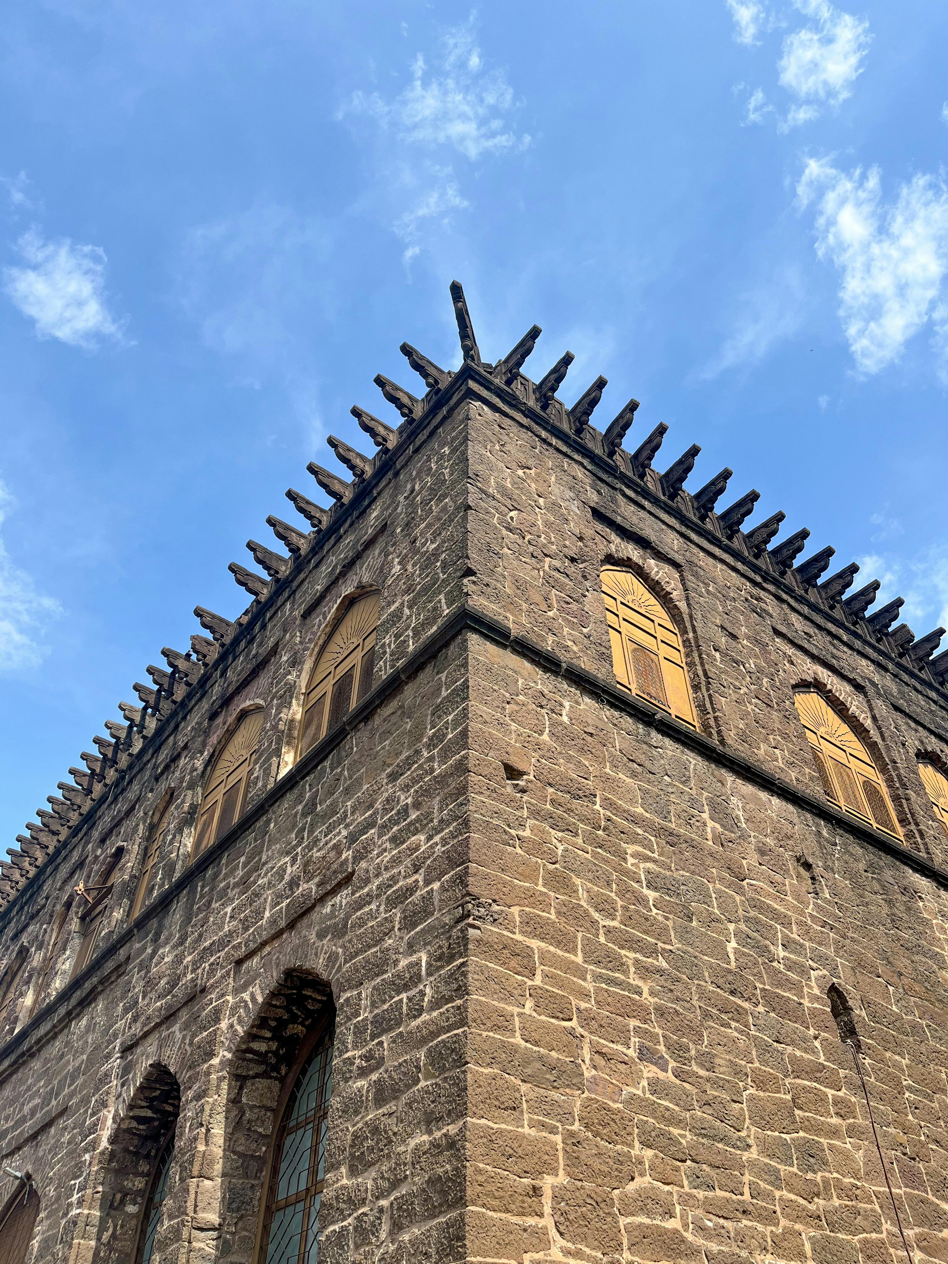 Free Explore the rich architectural heritage of a historic stone building in Vijayapura, India under a bright blue sky. Stock Photo