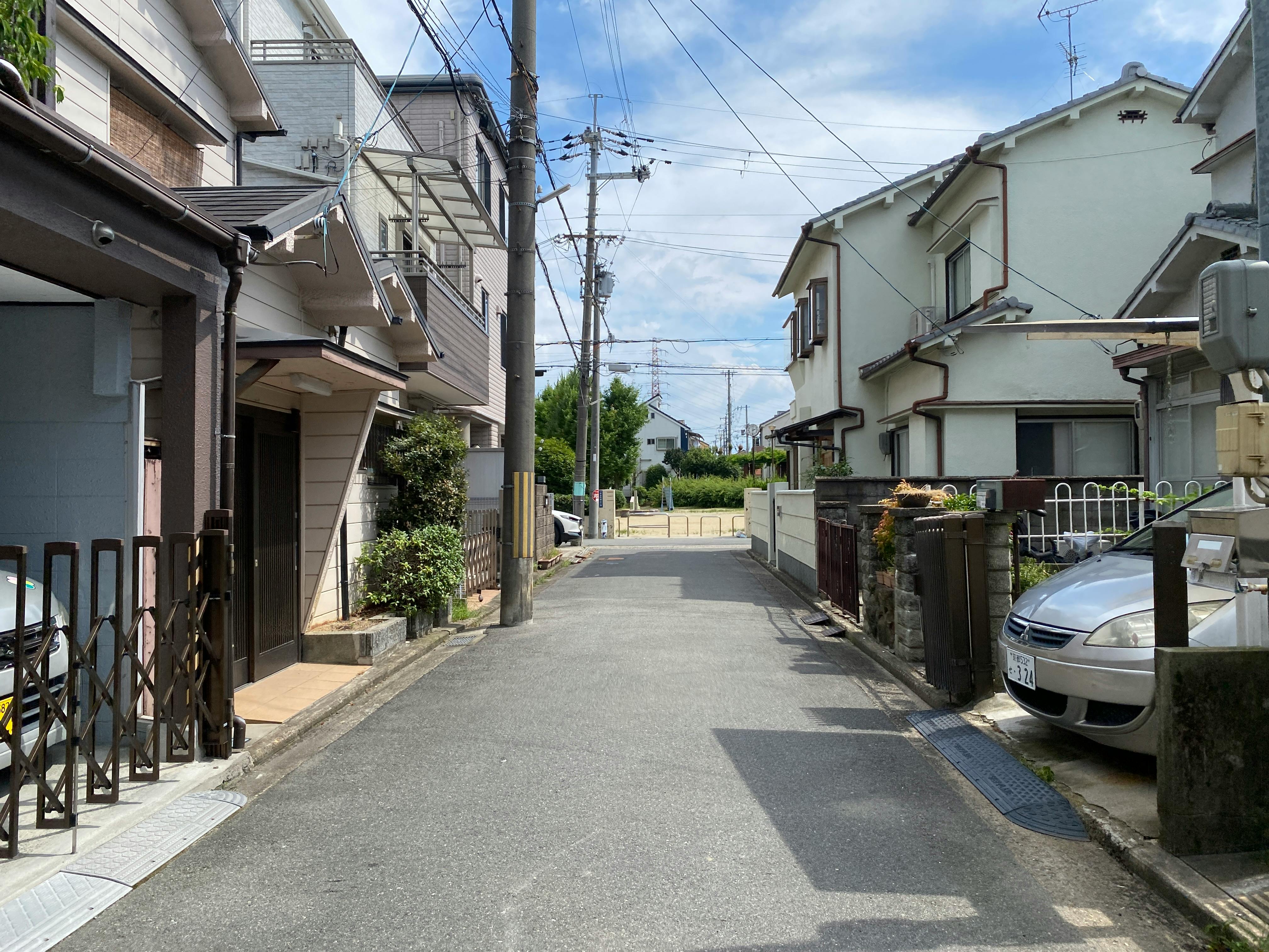 Calm residential street in a suburban area with clear blue sky and typical houses.