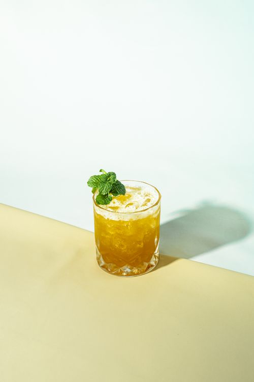 Free A chilled citrus cocktail garnished with mint leaves in a crystal glass on a table. Stock Photo
