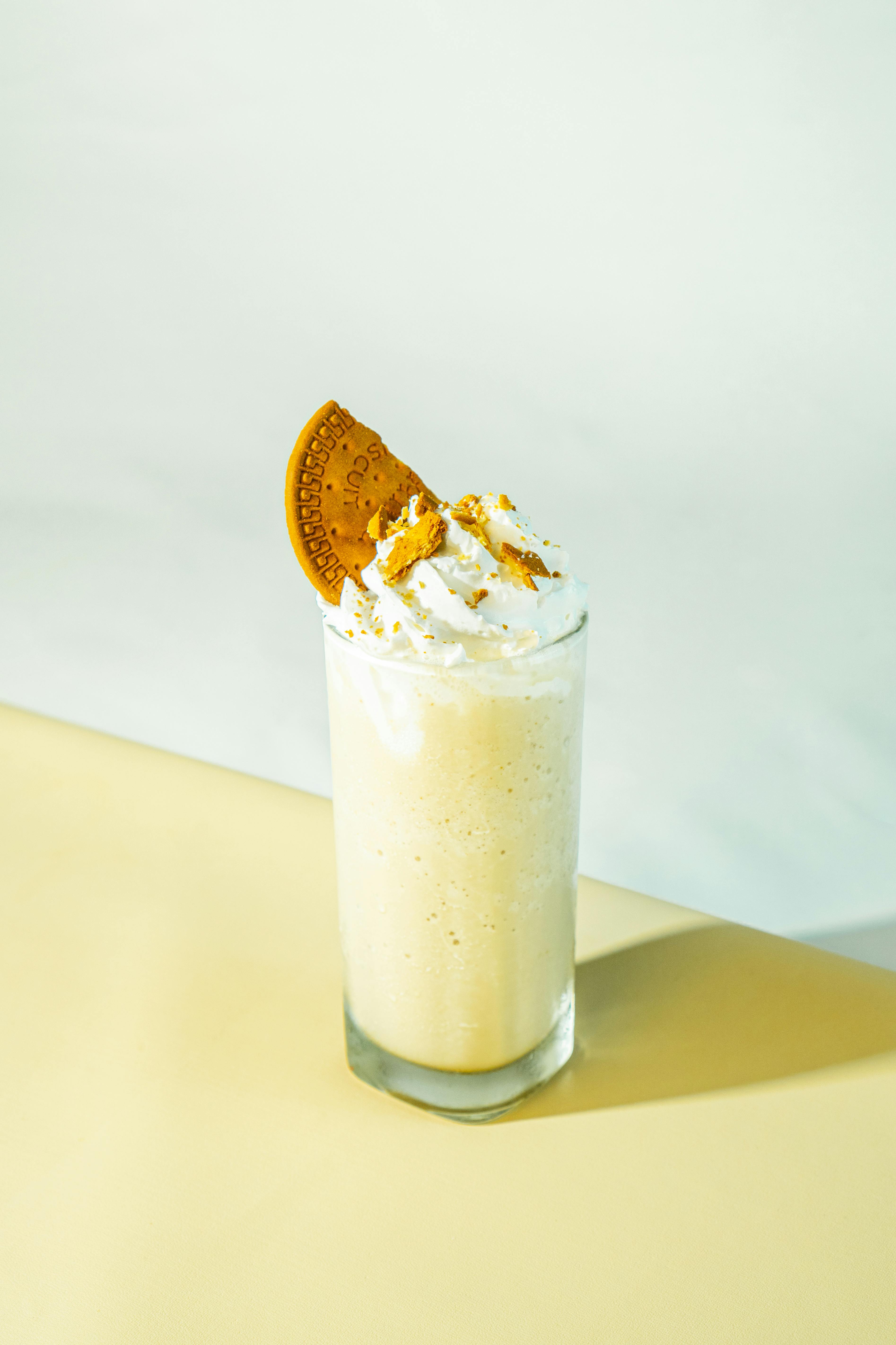 Delicious vanilla milkshake topped with whipped cream and a cookie, perfect for dessert.