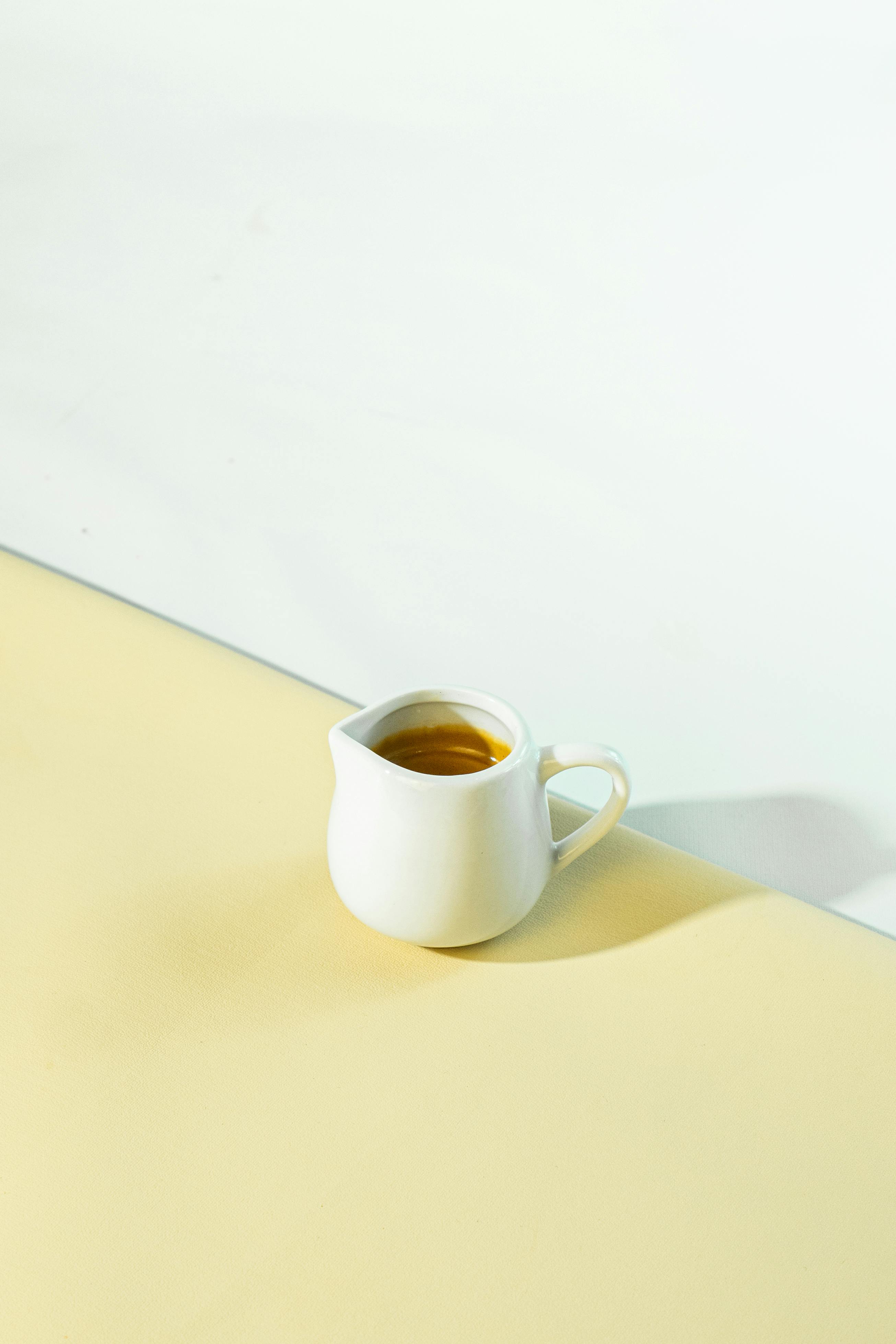 Kostnadsfria Enkel och elegant shot espresso i en vit keramisk kopp mot en mjuk bakgrund. Stock foto