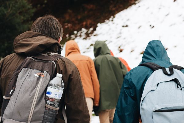 Men hiking single file up a mountain trail