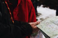 一名穿着冬装的成年男子正在户外查看地图