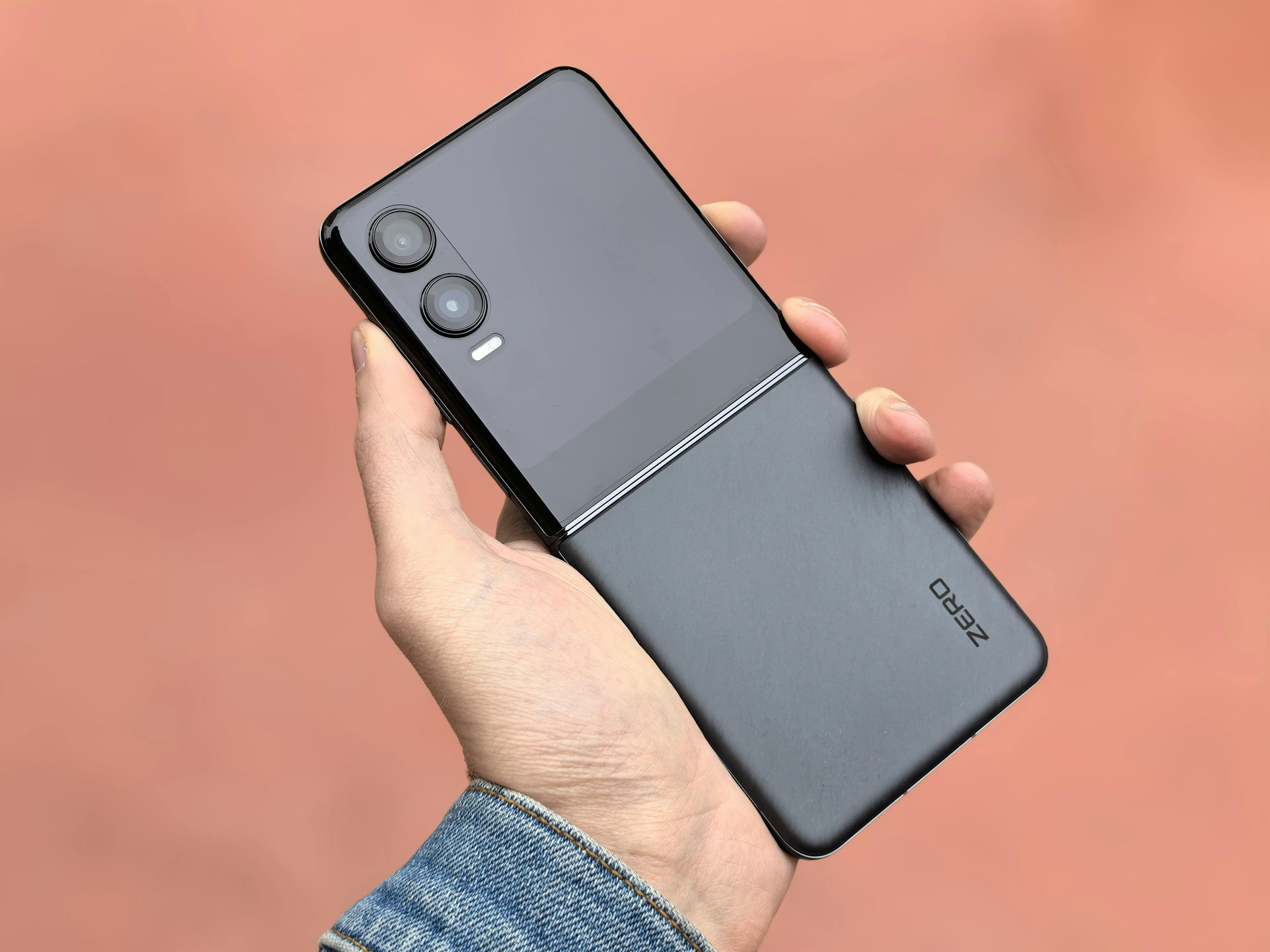 Close-up of a hand holding a modern black flip smartphone, ideal for tech and lifestyle concepts.