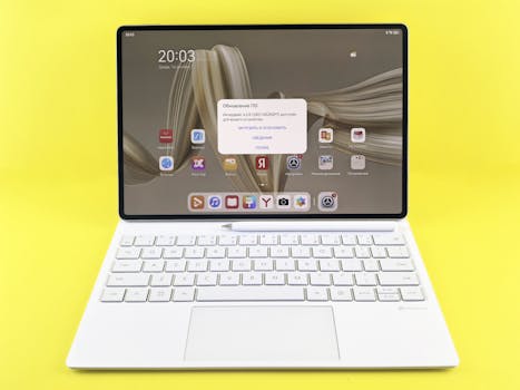 Sleek tablet with keyboard displaying a screen update prompt on a vibrant yellow background.