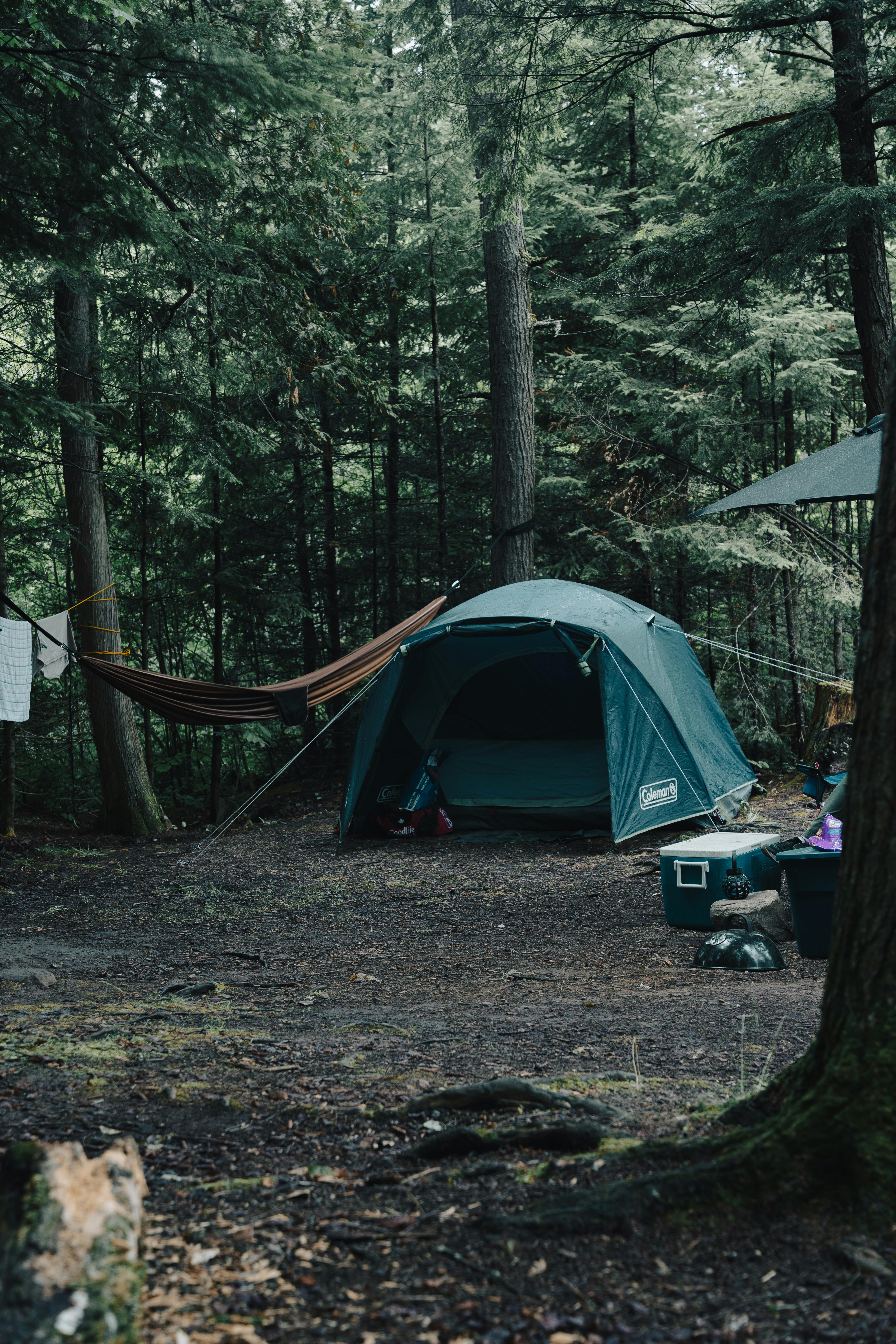 Down sleeping bag and sleeping pad laid out on a campsite groundsheet