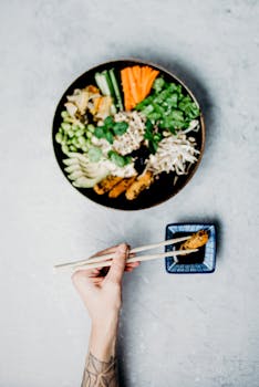 A vibrant Asian meal with vegetables and shrimp, featuring chopsticks and soy sauce, perfect for healthy dining imagery.