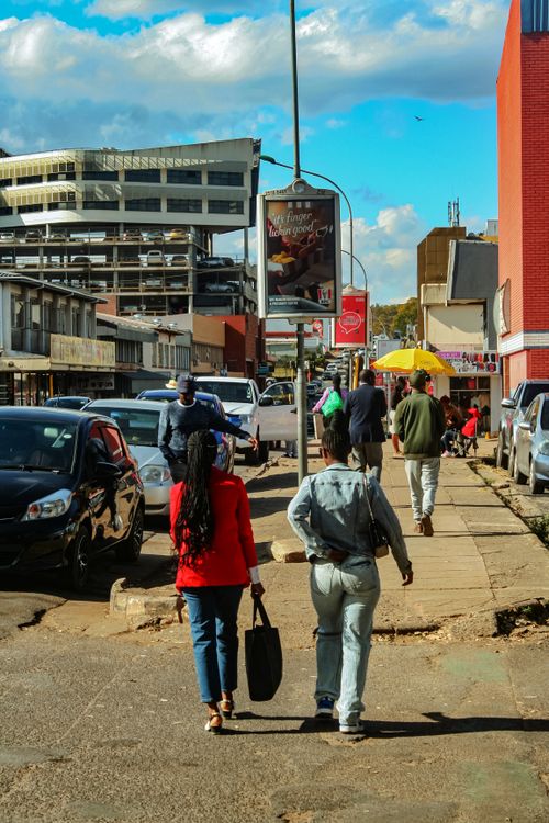 Free A busy street in Manzini, Eswatini with people walking and colorful buildings lining the road. Stock Photo