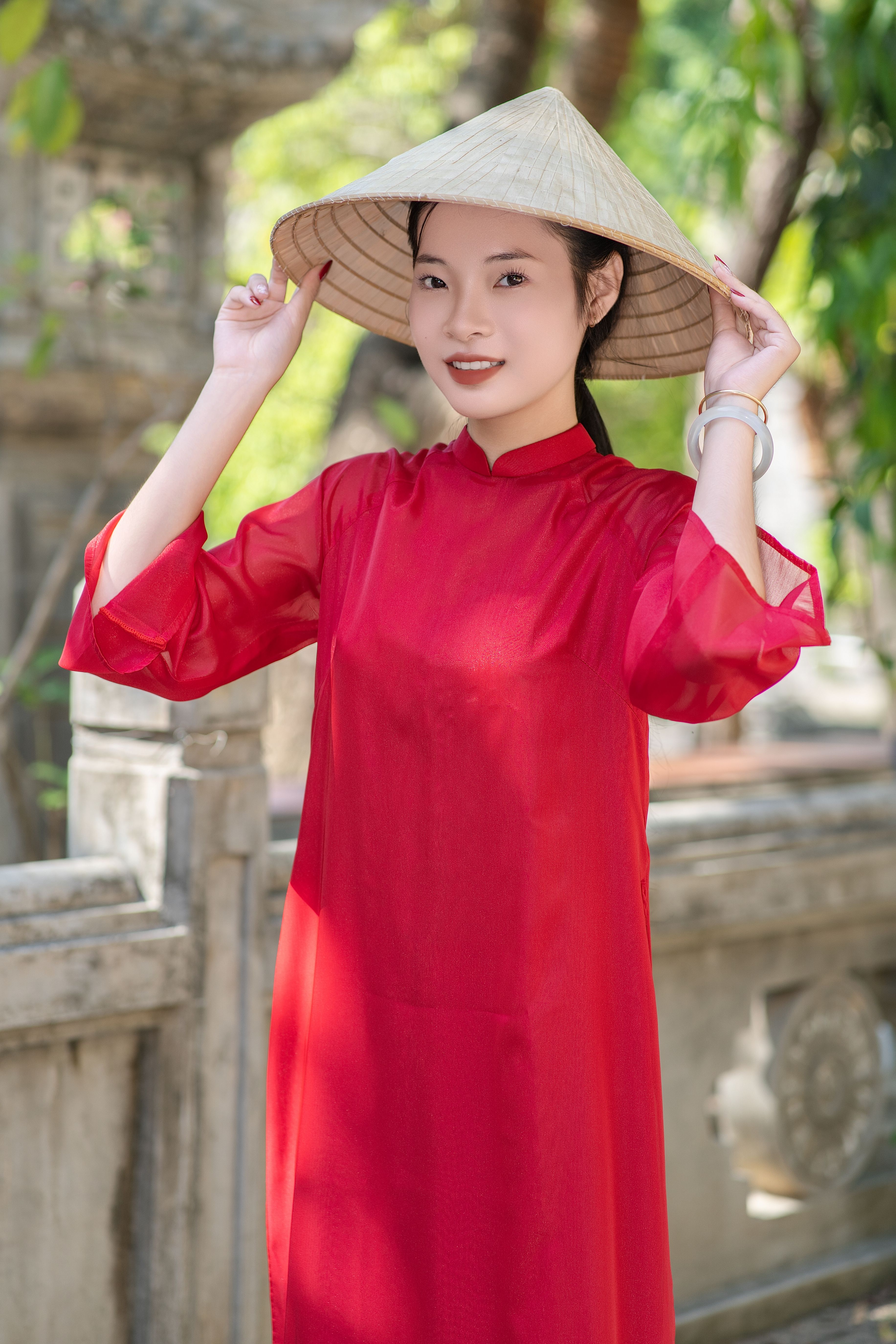 Woman in Red Dress Posing Outdoors with Conical Hat · Free Stock Photo