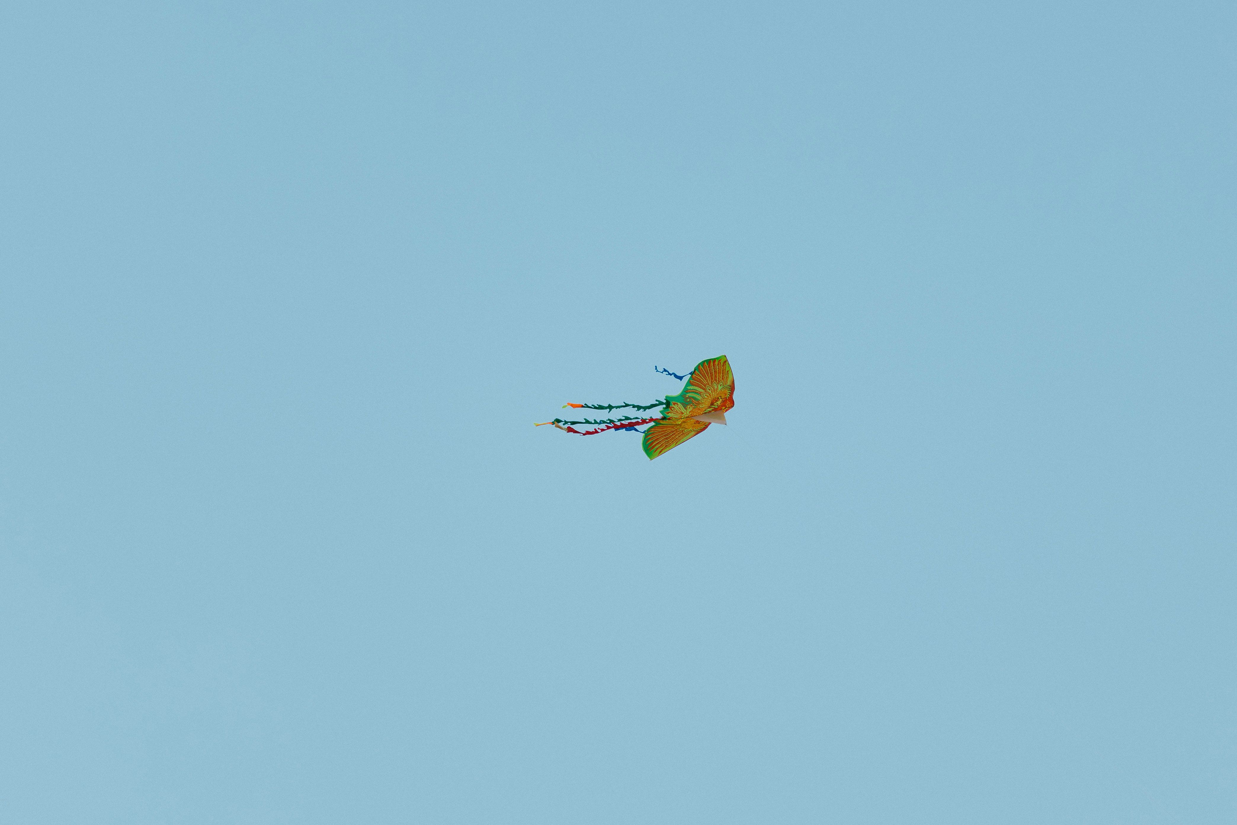 Vibrant Kite Soars Against Clear Blue Sky · Free Stock Photo