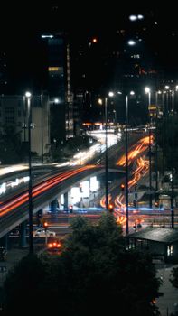 Dynamic night scene of blurred traffic lights on Warsaw's modern streets.