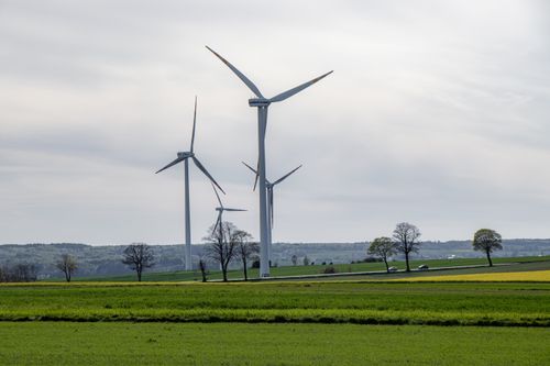 Free Scenic view of wind turbines in a green field, symbolizing renewable energy. Stock Photo